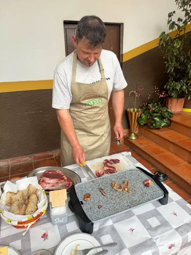 Hombre cocinando carne en una plancha y preparando plato